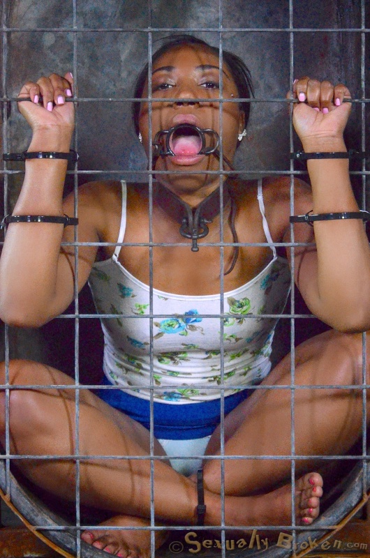 Caged ebony slave sucks a big black sausage